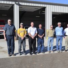 Representatives from the Quinter Volunteer Fire Department, QMC Construction and Midwest Energy pose in front of the department's new station in Nov. 2012.